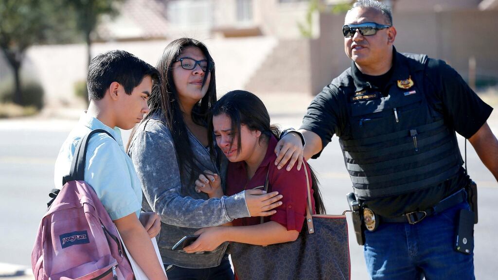 Students embrace after leaving campus after two teens were shot on Friday at Independence High School in the Phoenix suburb. Photograph: Matt York/AP