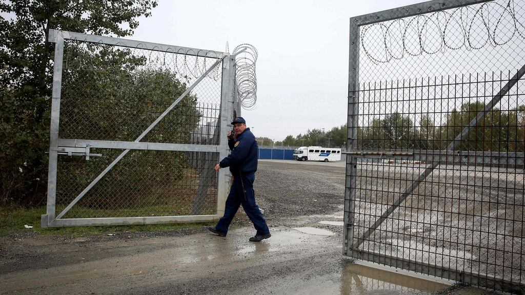 A member of the Hungarian police closes a razor-wired fence at a migrant transit centre near Roszke, at the border crossing with Serbia. File photograph: Oliver Bunic