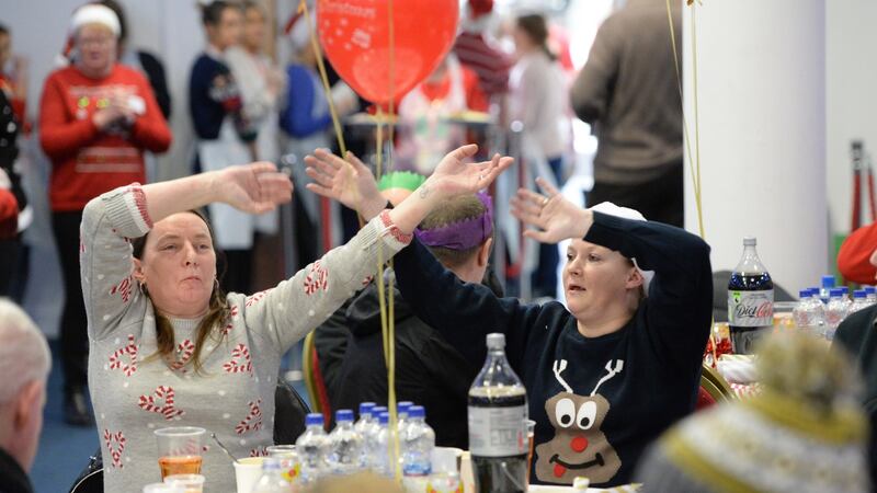 Patsy Haverty (left) and her sister Eileen Haverty, enjoy a sing along at the Knights of Columbanus Christmas dinner, at the RDS in Dublin on Christmas day. Photograph: Dara Mac Dónaill