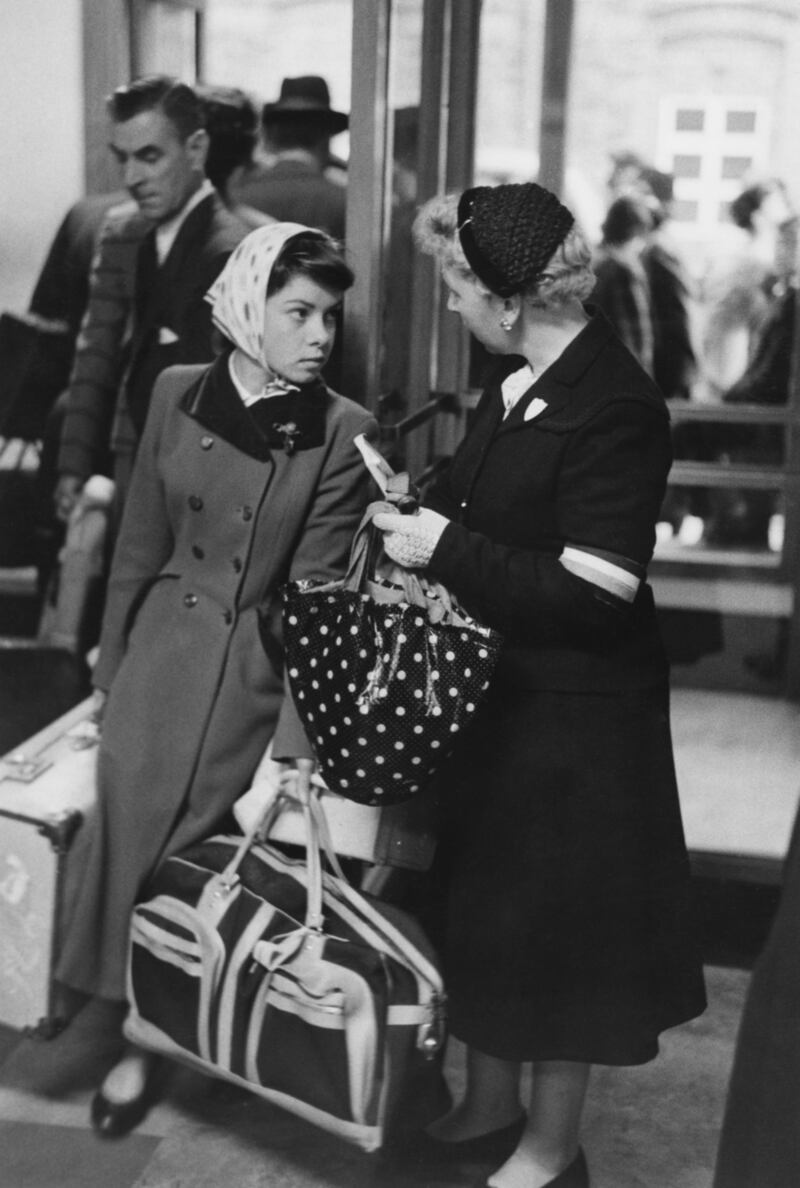 A Catholic voluntary worker (right) meets a young Irish immigrant on her arrival in London, October 1955. Original publication: Picture Post - 8041 - Why Do These Girls Leave Home? - pub. 8th October 1955 (Photo by Thurston Hopkins/Picture Post/Hulton Archive/Getty Images)