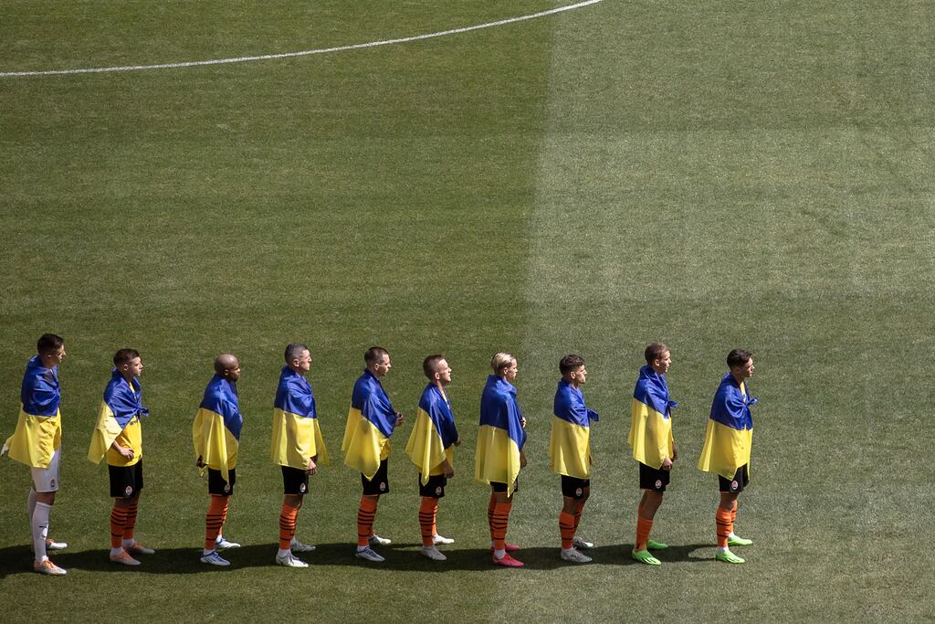 Players of Shakhtar Donetsk draped in Ukrainian flags stand before the opening soccer match of the new season of Ukrainian Premier League. Photograph: Roman Pilipey/EPA