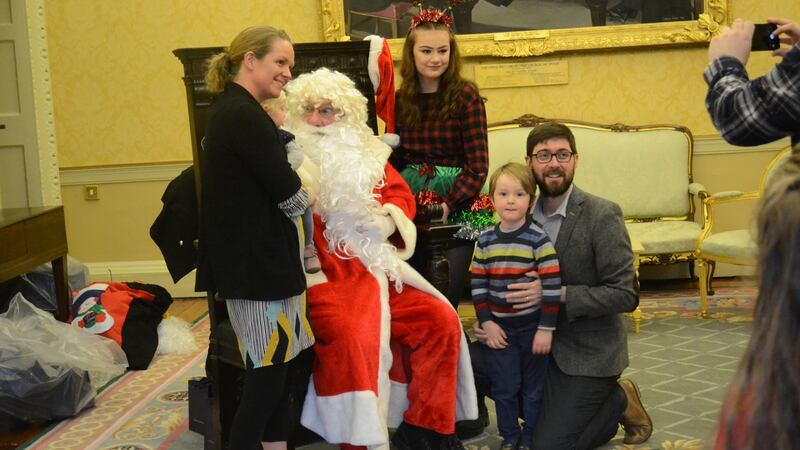 A family greet Santa Claus at Áras an Uachtaráin for an event turning on the Christmas tree lights on Saturday. Photograph:  Hajar Akl
