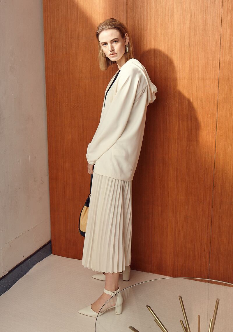 Hooded top €175 Marella, pleated skirt €79 Selected Femme, bag €270 Furla, shoes €115 Kurt Geiger, earrings €85 Dryberg/Kern, West Elm Starburst coffee table €599