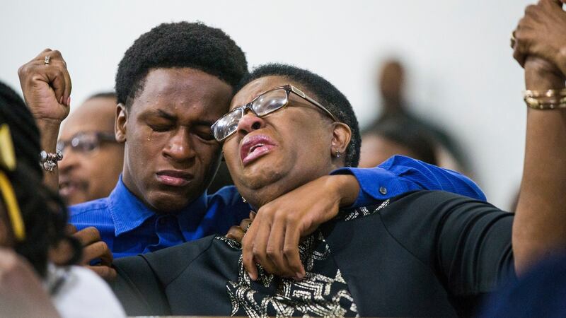 Allison Jean raises her hands in the air as she leans on her son, Grant (15) during a prayer service for her son and Grant’s brother Botham Jean at the Dallas West Church of Christ on Sunday. Photograph: Shaban Athuman/The Dallas Morning News/AP