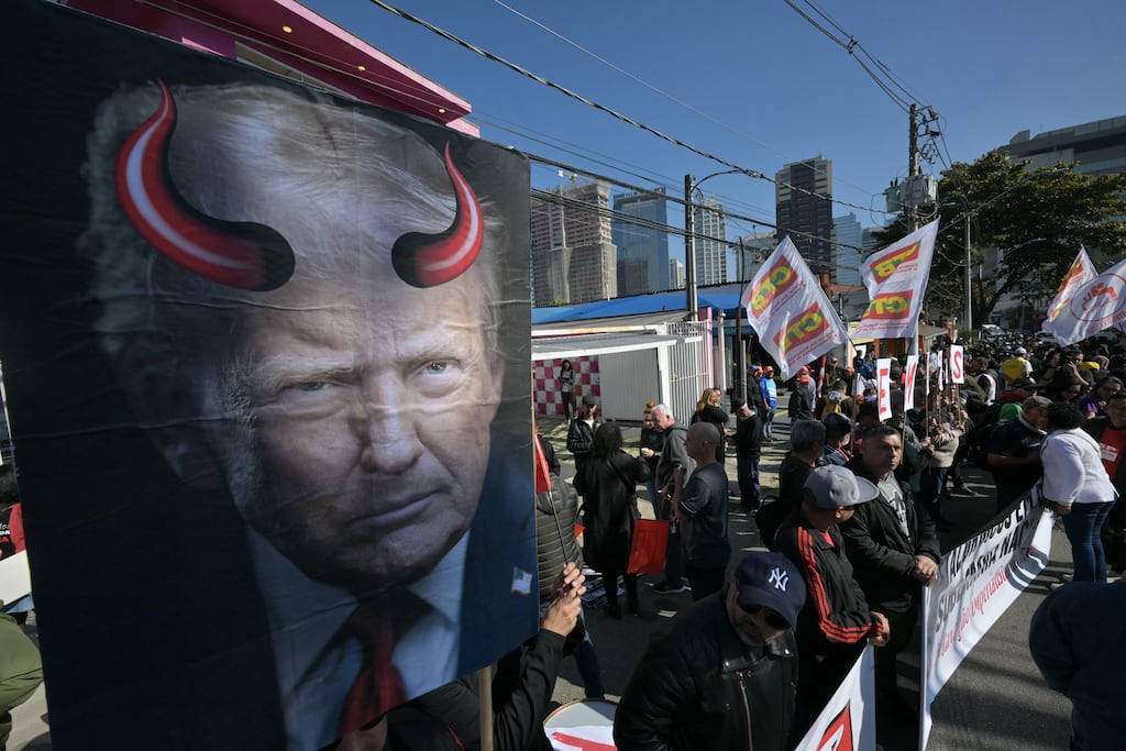 An activist holds a poster depicting US president Donald Trump bearing devil horns near the US consulate, in Sao Paulo, Brazil. Photograph: Nelson Almeida/AFP via Getty Images