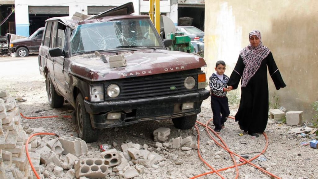 People walk next to a vehicle damaged by what residents say was a missile fired from the Syrian rebels in the town of Hermel in Bekaa this week. Photograph: Mohamed Azakir/Reuters