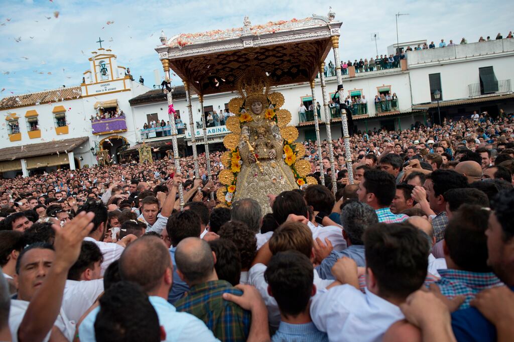 Pilgrims gather around a statue of the Virgin Mary being paraded during a procession in the village of El Rocio, southern Spain. Photograph: Jorge Guerrero/AFP via Getty Images