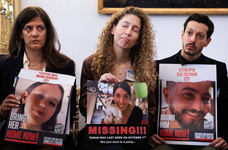 Relatives and acquaintances hold pictures last month of people missing or held hostage in the wake of the Hamas October 7th attack, including Noam Avigdori (12), pictured in the poster on the left. Photograph: Emmanuel Dunand/AFP via Getty Images