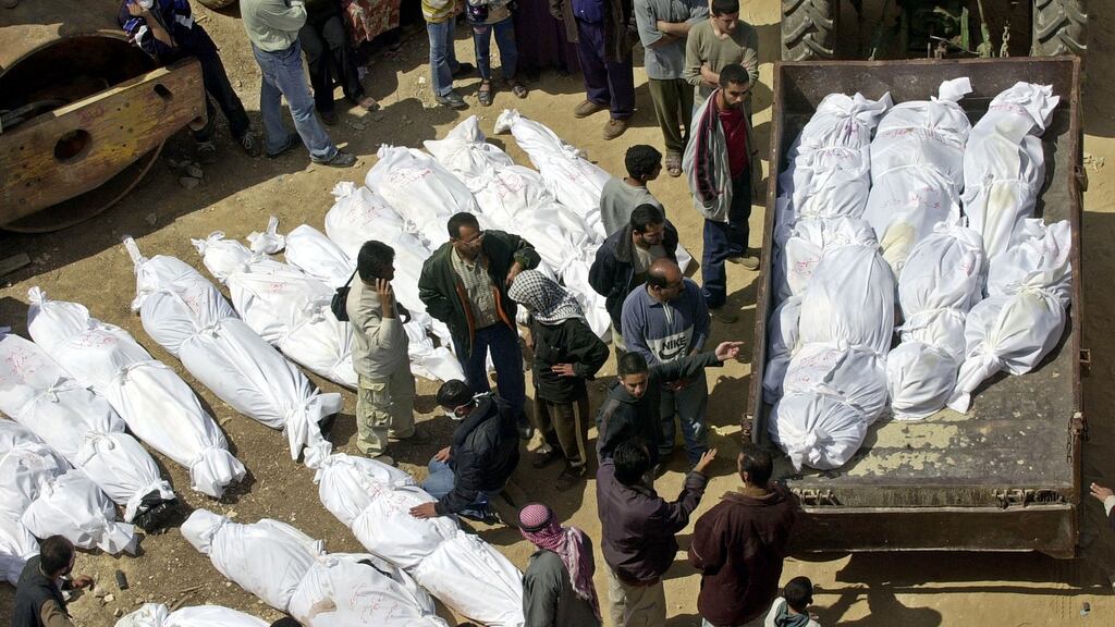 Palestinians prepare shrouded bodies for a mass funeral on April 19th, 2002 in the West Bank city of Jenin.  Photograph: Scott Nelson/Getty Images