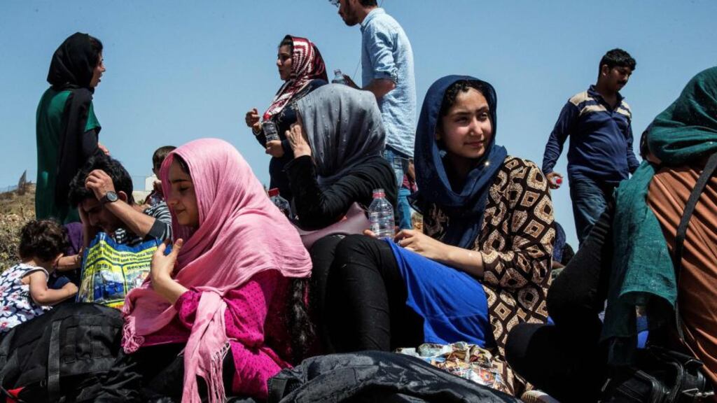 Refugees and migrants sit on the ground upon their arrival with a boat near the village of Finokalia in the southern Greek island of Crete on Tuesday. Photograph: AFP/Getty Images