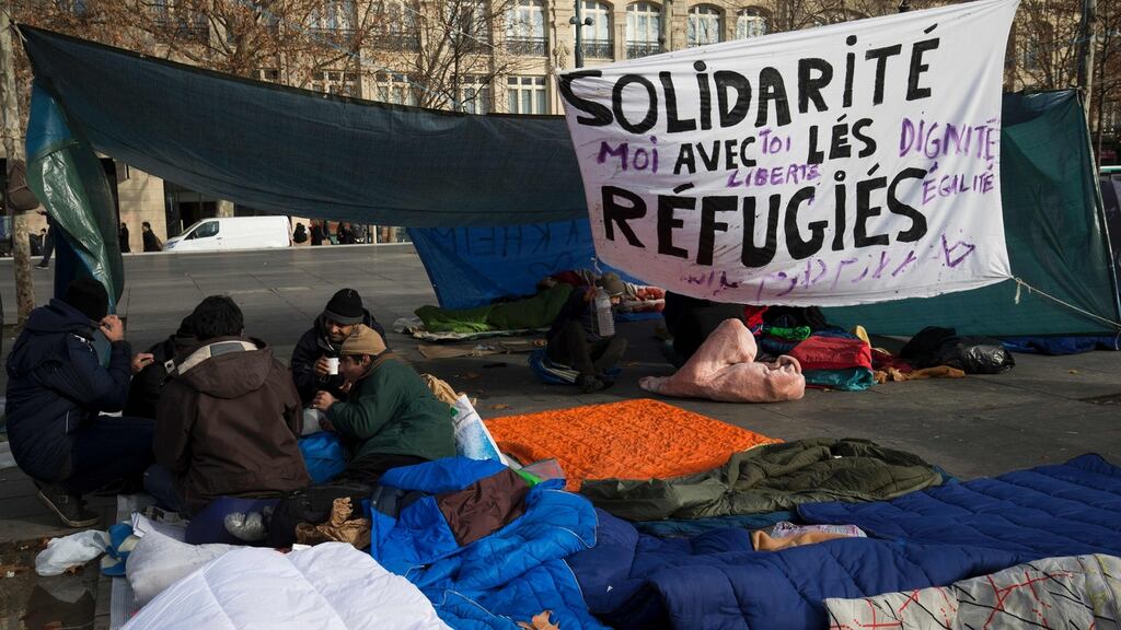 Refugees and migrants from several countries, including Iran, Pakistan, Iraq and Erythea, sit by a makeshift camp on the Place de la Republique square in Paris. Photograph: Getty Images