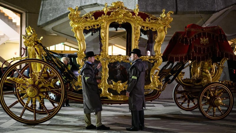 Members of the coach team discuss procedures as they stand next to the state coach, believed to be oldest ceremonial vehicle in regular use in the world. Photograph: Leon Neal/Getty