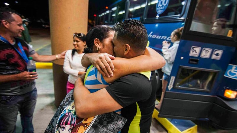 Cuban migrant Mailin Perez (front left)  embraces her husband Jose Caballero after arriving via Mexico at a bus station in Austin, Texas. Almost a year after he smuggled his way out of Cuba on a homemade boat, Caballero was reunited  with his wife who survived a harrowing sea voyage of her own last month. Photograph: Ashley Landis/Reuters.