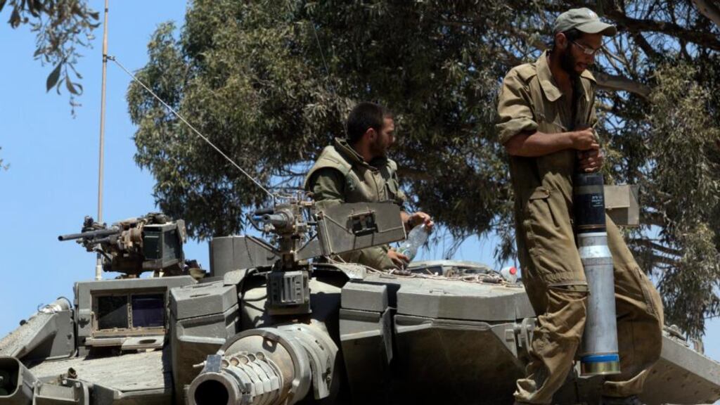 ‘The humanitarian situation in Gaza is disastrous and Israel’s violations of international law are horrific, but there are questions of equivalence to be asked, at the very least at the time of the vote.’ Above, an Israeli soldier carries a tank shell onto a Merkava tank inside southern Israel, close to the Gaza Strip, yesterday. Photograph: Jim Hollander/EPA