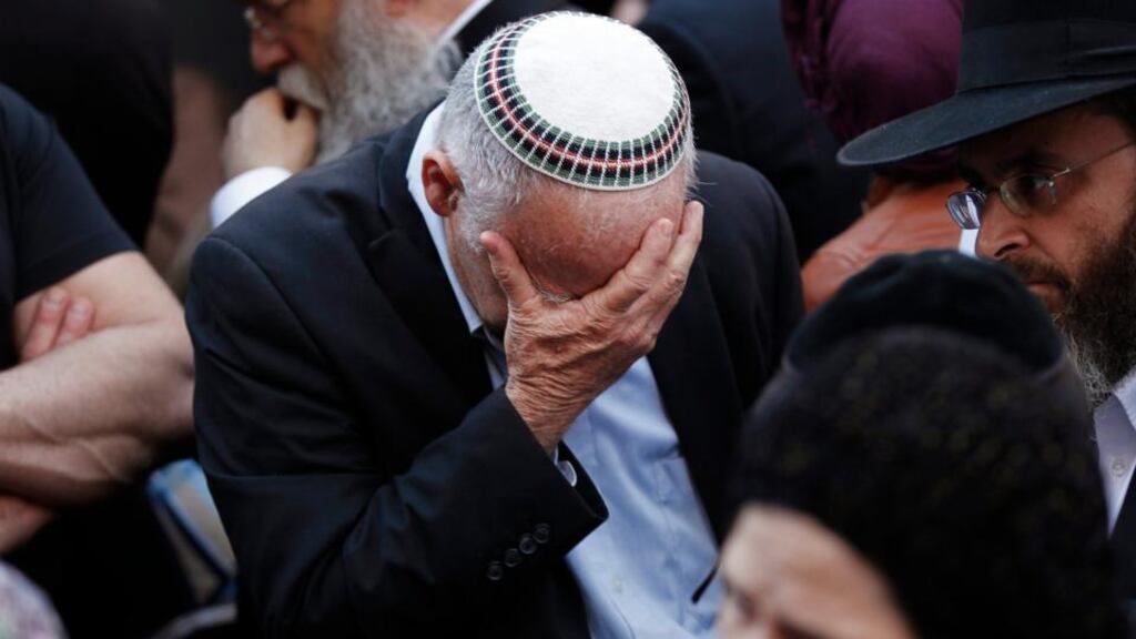 An Israeli mourns during the funeral of Aryeh Kopinsky, Calman Levine and Avraham Shmuel Goldberg in Jerusalem. Two Palestinians armed with a meat cleaver and a gun killed four worshippers, including Kopinsky, Levine and Goldberg in a Jerusalem synagogue today before being shot dead by police. It was the deadliest such incident in six years in the holy city amid a surge in religious conflict. Photograph: Finbarr O’Reilly/Reuters