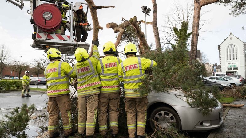 Members of Ennis fire brigade free a car from under a tree felled by Storm Ciara at Friars Walk, Ennis on Sunday. Photograph: Eamon Ward