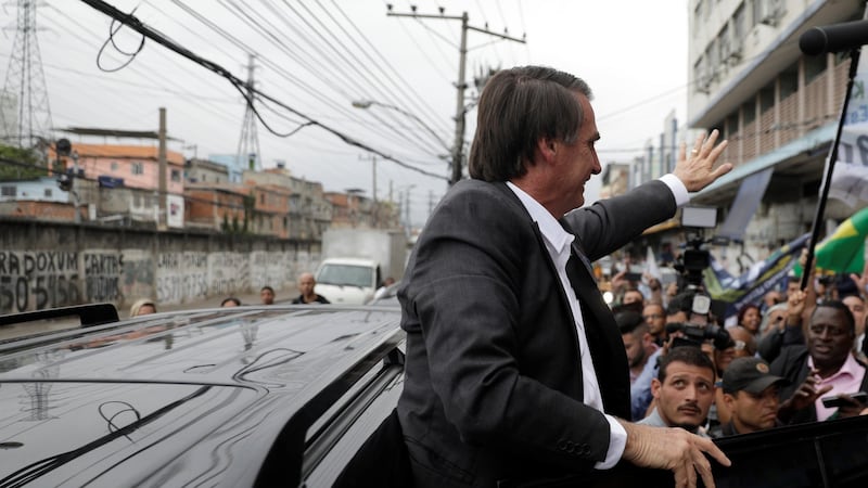 Presidential candidate Jair Bolsonaro gets into his car after attending a rally at the popular Mercadao de Madureira market in Rio de Janeiro, Brazil. Photograph: Ricardo Moraes/Reuters