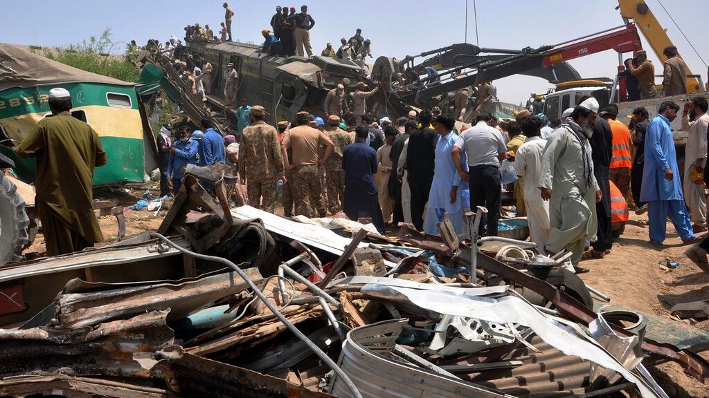 Soldiers and volunteers working to rescue survivors at the site of a train crash in Ghotki district, southern Pakistan. Photograph: Waleed Saddique/AP Photo