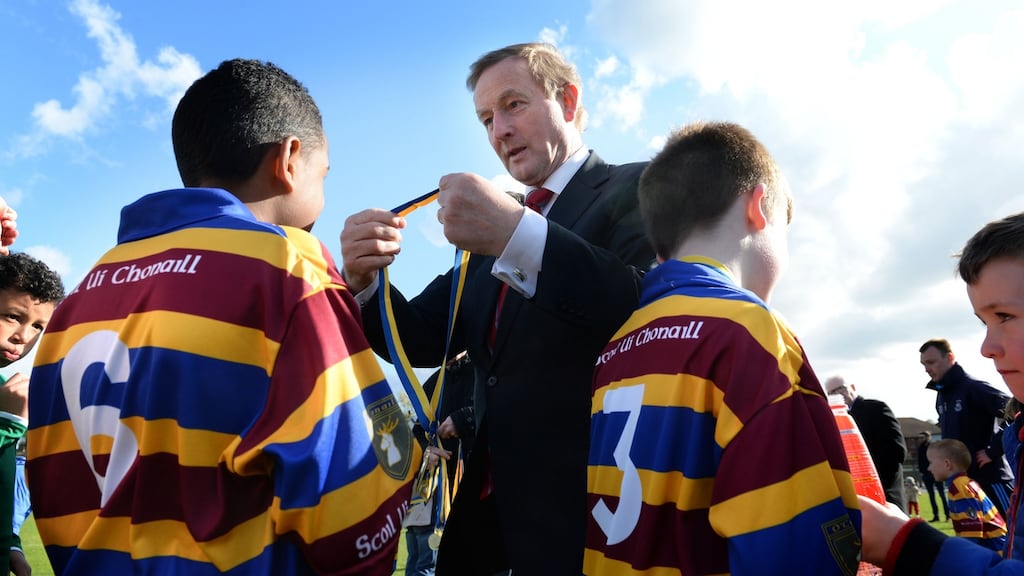 Scoil Uí Chonaill: Enda Kenny presents medals to young members of the GAA club, who played St Laurence O’Toole at the club’s new facilities. Photograph: Dara Mac Dónaill
