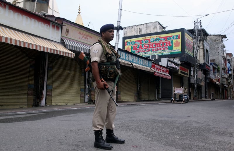 A security personnel stands guard next to closed shops in Jammu on Wednesday. Photograph: Rakesh Bakshi/AFP/Getty Images