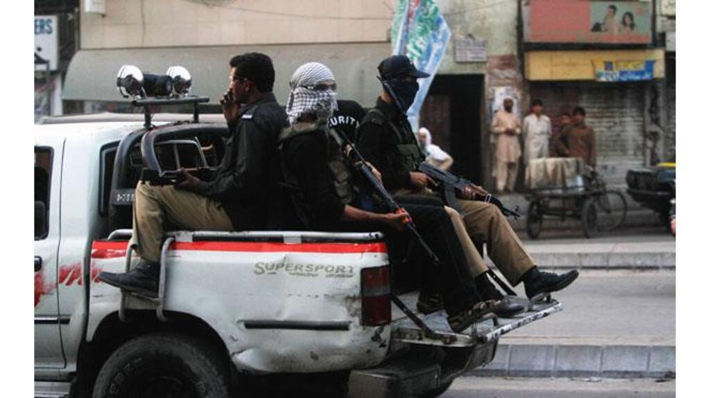 Policemen patrol a street during funeral prayers for victims killed by unidentified gunmen in Karachi yesterday. Photograph: Athar Hussain/Reuters