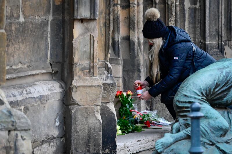 A mourner lights a candle near the Christmas market. Photograph: John Macdougall/AFP/Getty