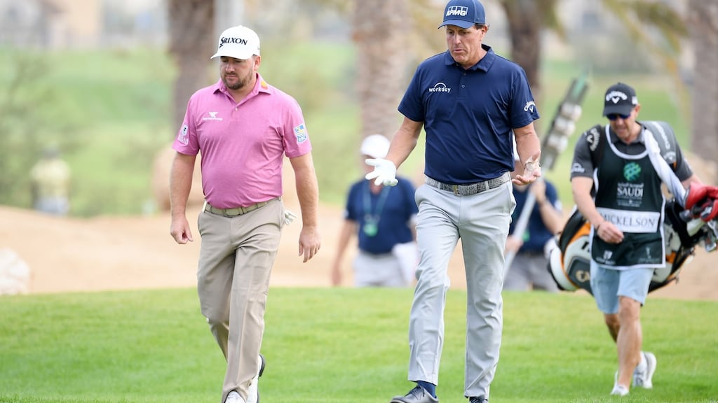 Graeme McDowell and Phil Mickelson walk along the 14th hole during the second round of the Saudi International at Royal Greens Golf and Country Club in King Abdullah Economic City, Saudi Arabia. Photograph: Ross Kinnaird/Getty Images