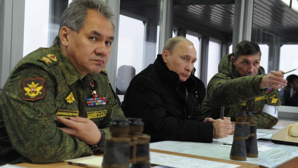 Vladimir Putin is flanked by Russian defence minister Sergey Shoigu (left) and army training chief Ivan Buvaltsev at military exercises near St Petersburg. Photograph: EPA/Mikhail Klimentyev