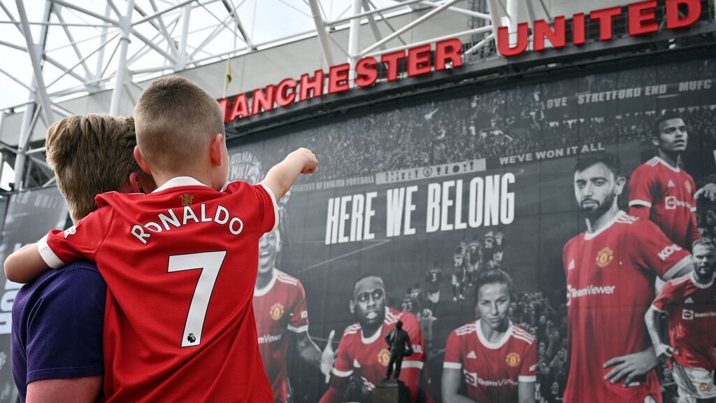 A young fan wearing the shirt of Manchester United’s new signing Cristiano Ronaldo outside Old Trafford stadium in Manchester. Photograph: Paul Ellis/AFP via Getty Images