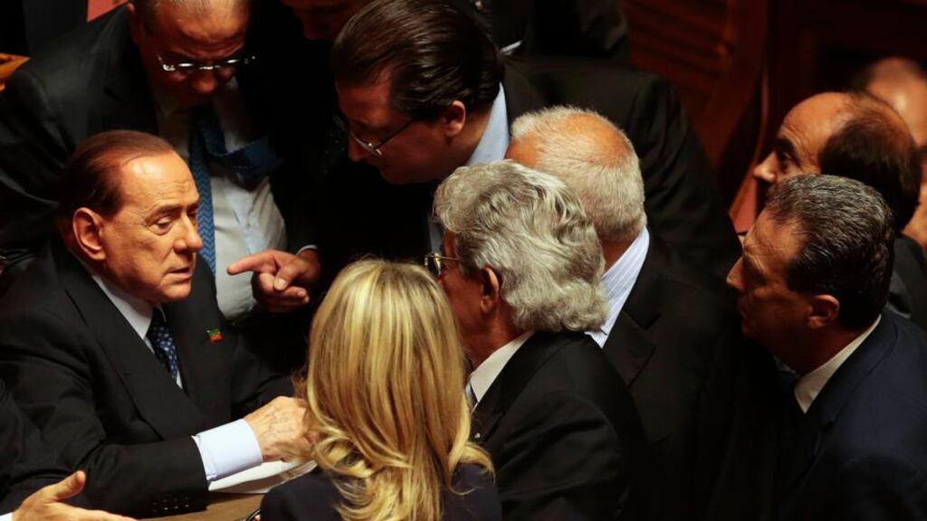 Italian center-right leader Silvio Berlusconi (left) talks with senators at the Senate after Italy’s Prime Minister Enrico Letta’s asking for a possible call for a confidence vote immediately in Rome today. Photograph: Tony Gentile/ REUTERS