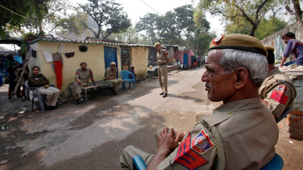 Police sit inside the Ravi Das cam where four of the six accused in a rape case including Ram Singh reside. PhotographMansi Thapliyal/Reuters