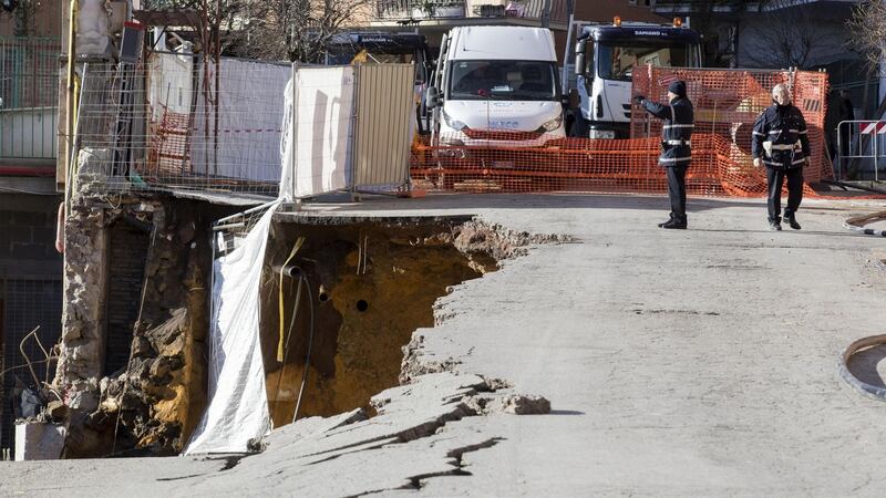 Policemen, firefighters and technicians work at the Via Livio Andronico to restore the road the day after a sinkhole opened up. Photograph: Massimo Percossi/EPA