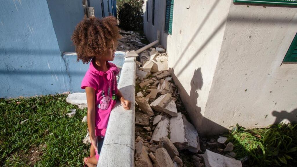 A girl views fallen pieces of a church roof after Hurricane Gonzalo passed through in Sandys Parish, western Bermuda. Photograph: Nicola Muirhead/Reuters