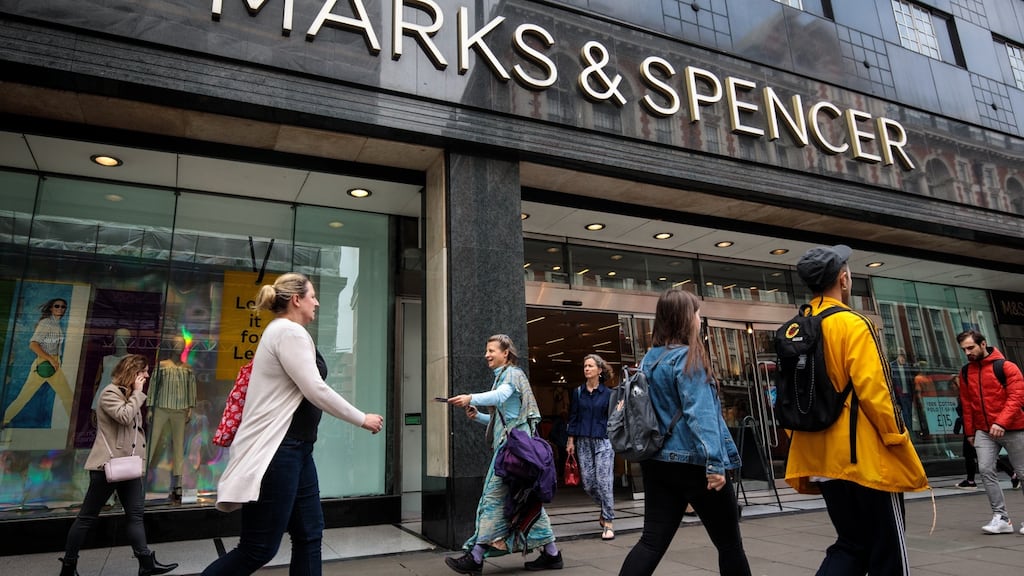 Shoppers walk past a Marks and Spencer (M&S) store on Oxford Street in London.