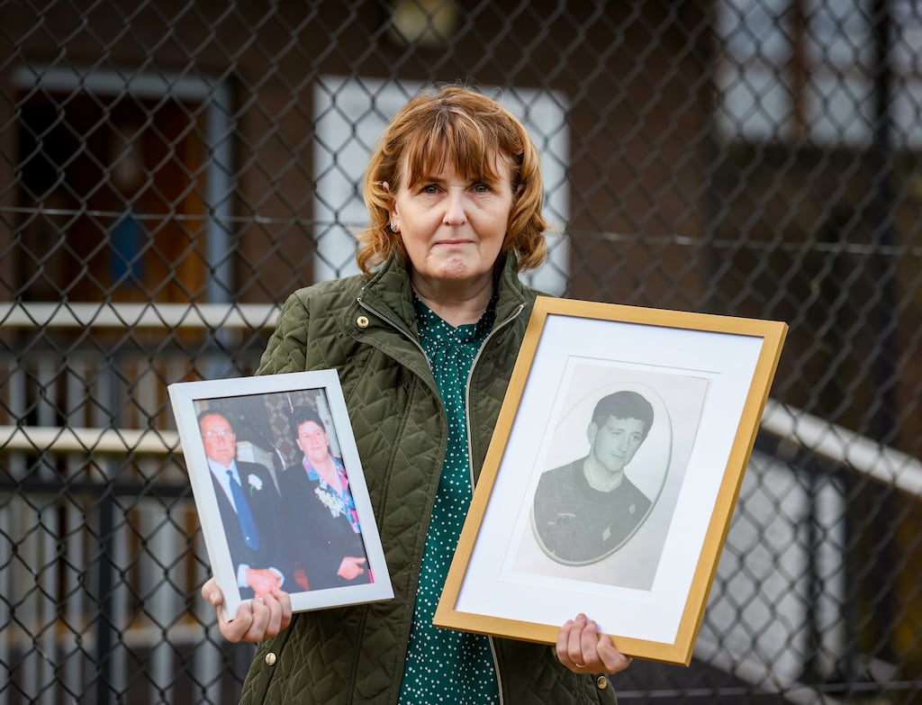 Bernadette McKearney, widow of Kevin McKearney, holding photographs of her husband and her parents Charlie and Tess Fox. The three were shot dead by UVF gunmen. Photograph: Liam McBurney/PA