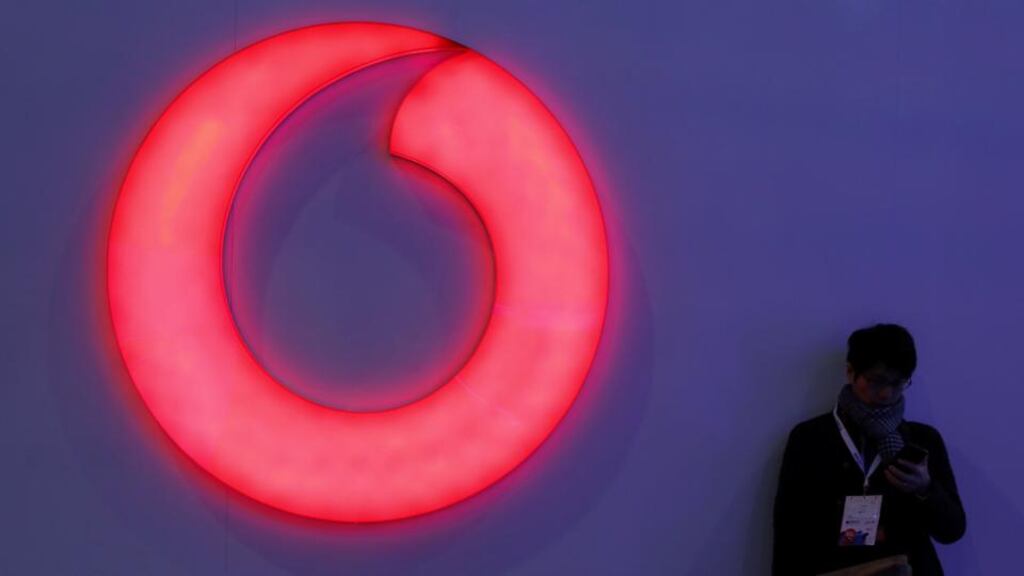 A man checks his mobile phone next to a Vodafone logo at the Mobile World Congress in Barcelona, Spain on February 28th, 2018. Photograph: Sergio Perez/Reuters/File Photo