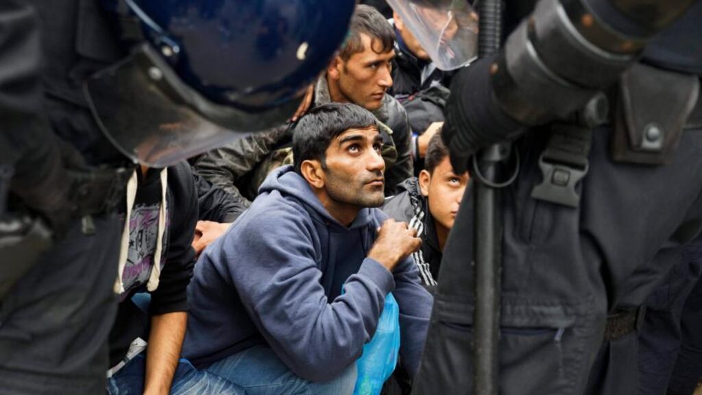 Migrants wait in front of Croatian police officers near the entrance of a reception centre close to Croatia’s border with Serbia in Opatovac. European governments have pushed through by majority vote a divisive deal to share the resettlement of 120,000 refugees across the bloc. Photograph: Zoltan Balough/EPA.