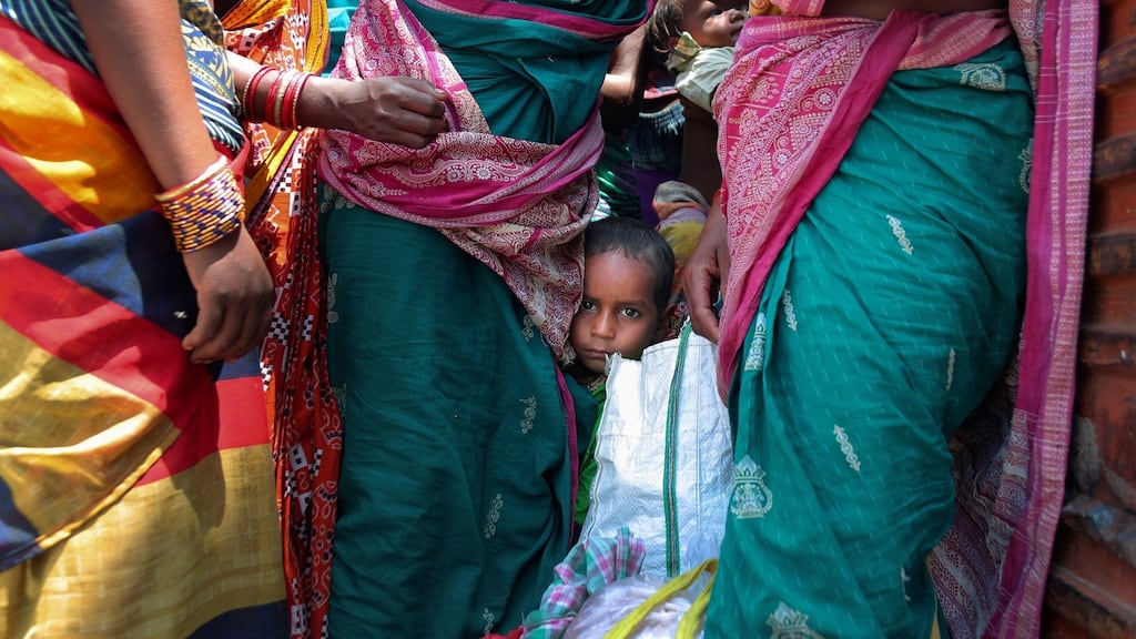 A child of a migrant worker waits with others for transportation in Hyderabad, India. Migrant workers are becoming infected at an alarmingly high rate, leading to fresh outbreaks in villages across northern India. Photograph: Mahesh Kumar A/AP Photo