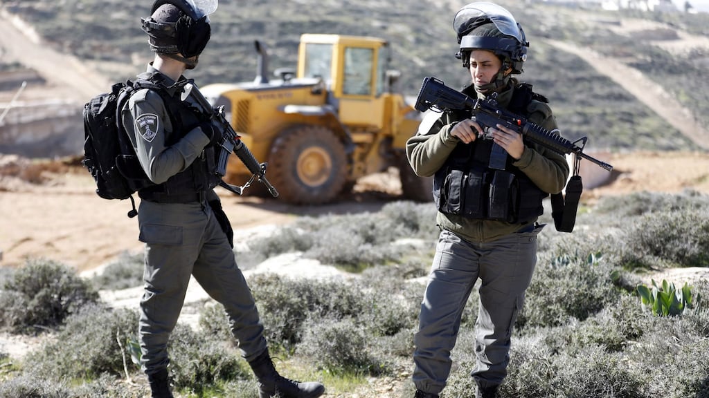 Israeli soldiers stand guard as Israeli bulldozers demolish walls on a Palestinian land near the West Bank city of Yatta, south of Hebron on January 23rd. Photograph: Abed Al Hashlamoun