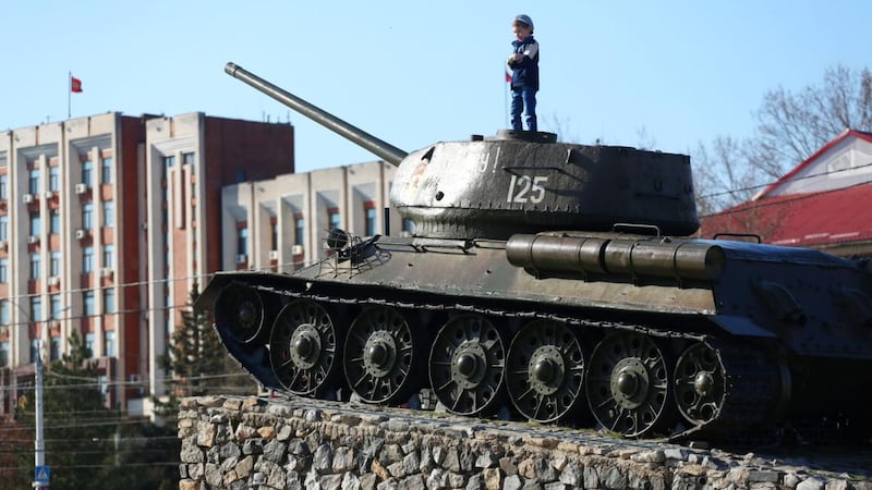 A child stands on the T-34 Soviet tank set as a monument in the centre of Tiraspol. Photograph: Aleksey Filippov/AFP via Getty Images