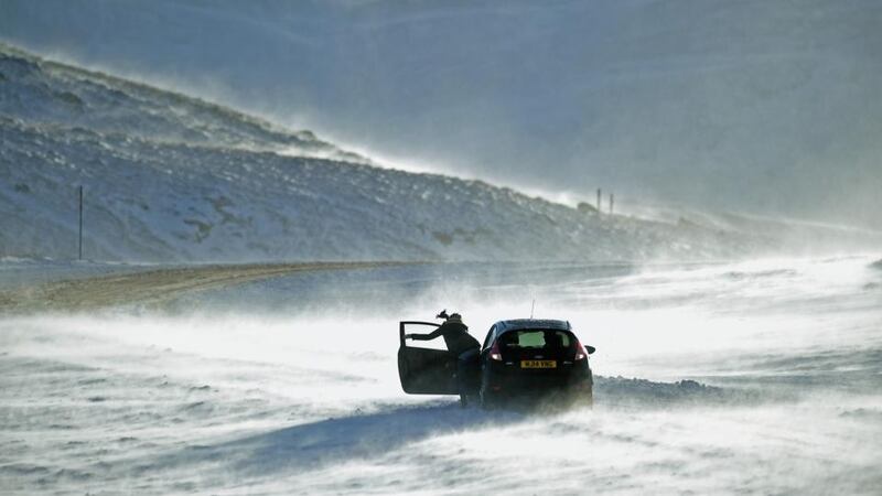 People push a car stuck on the A93 Braemar to Glenshee road in Scotland. Photograph:Jeff J Mitchell/Getty Images