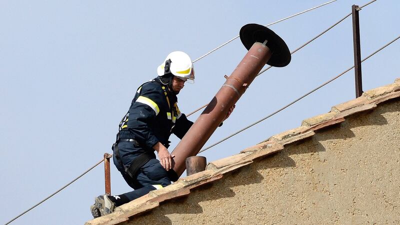 A member of the fire and rescue service sets a chimney on the roof of the Sistine Chapel at the Vatican Photograph: Dylan Martinez/REUTERS