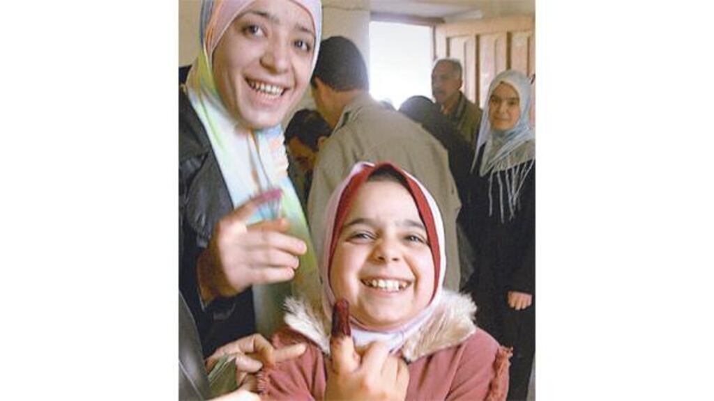 A young Iraqi girl shows her inked finger after her mother and grandmother voted in Baquba, 50km north of Baghdad, yesterday.