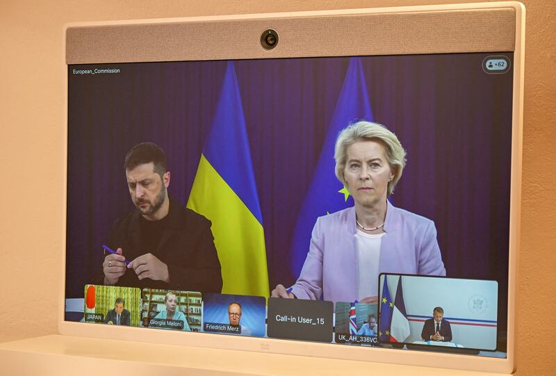 Ukrainian president Volodymyr Zelenskiy and European Commission president Ursula von der Leyen appear on a screen during a video conference with French president Emmanuel Macron. Photograph: Philippe Magoni/Getty Images