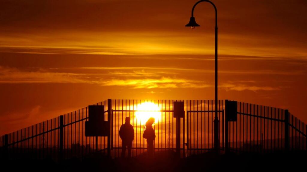 A couple watch the sun set on St Kilda beach in Melbourne. Ireland now accounts for about 8 per cent of all subclass 457 visas issued there. Only the United Kingdom and India get more, but on a per capita basis, Ireland is far ahead. Photograph: Mick Tsikas/Reuters