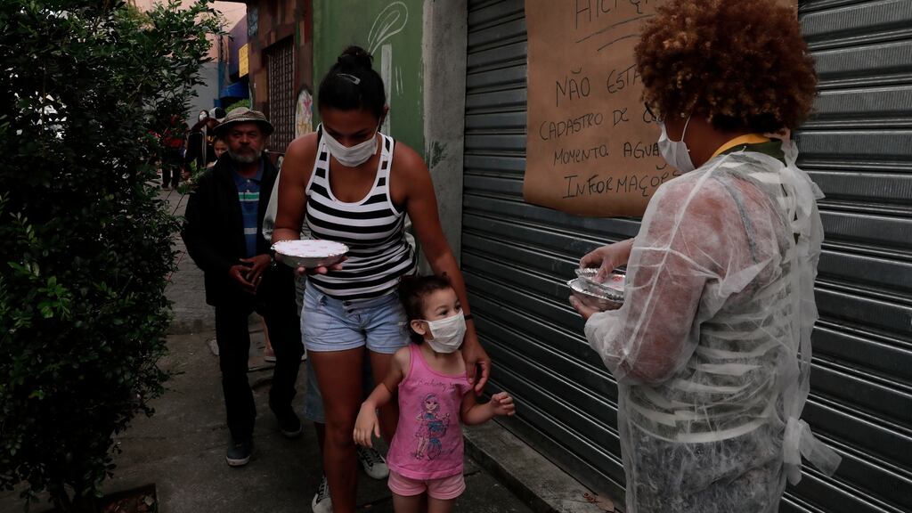 Volunteers members of Associacao Acao Comunitaria Nova Heliopolis distribute food in Heliopolis favela during the coronavirus pandemic in Sao Paulo, Brazil. Photograph: Rodrigo Paiva/Getty