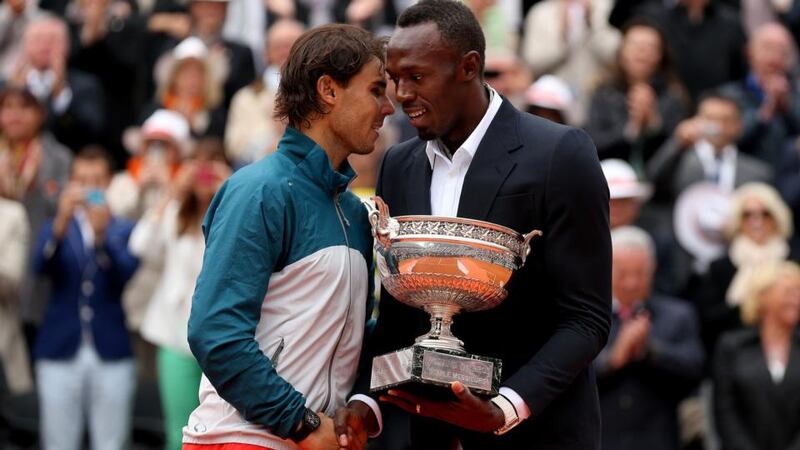 Rafael Nadal is presented with the Coupe des Mousquetaires trophy by Usian Bolt after the men’s singles final against David Ferrer at the French Open at Roland Garros in Paris. Photograph: Matthew Stockman/Getty Images