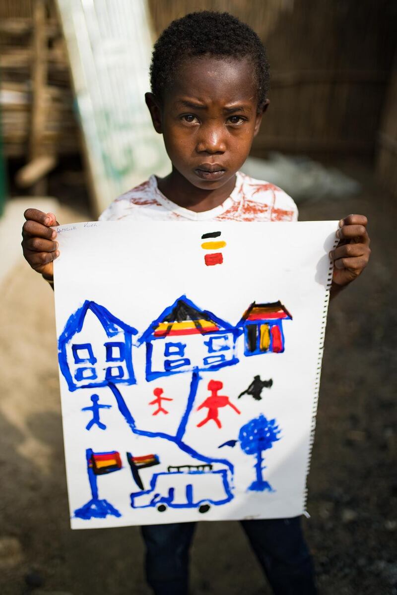 Gatkuoth Kueh, a participant in Irish artist Brian Maguire’s workshop, holds up her resulting painting. A lot of these paintings revealed what had happened to the children during the conflict that led them to the camp in Bentiu. Photograph: Steve De Neef/Concern Worldwide.