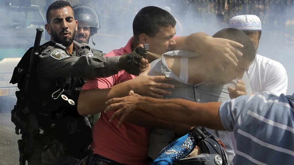 An Israeli border policeman uses pepper spray on a Palestinian man during clashes in Arab East Jerusalem on Friday. Photograph: Ammar Awad/Reuters.