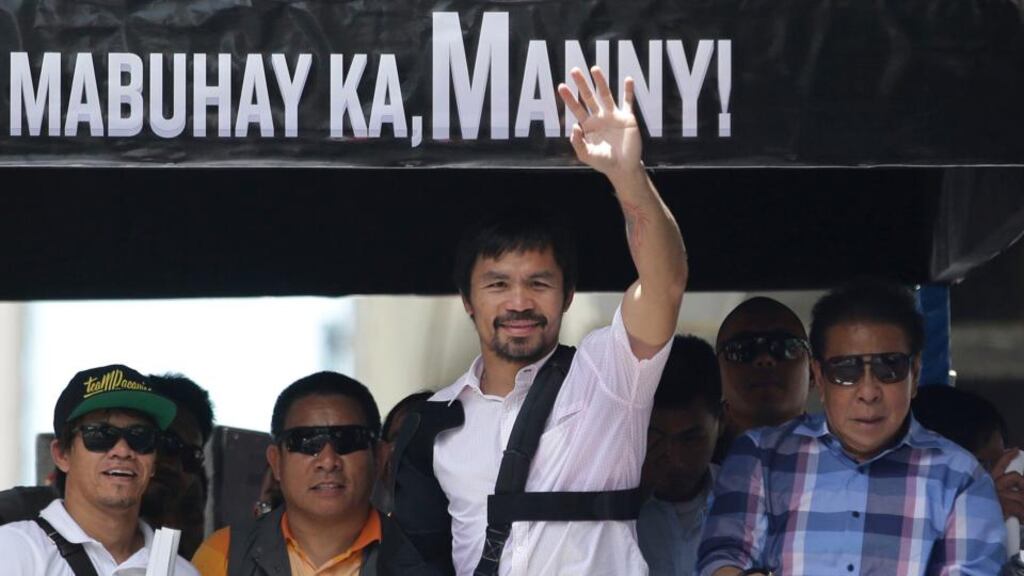 Filipino boxer Manny Pacquiao waves to crowds after arriving back in Manila following his defeat to Floyd Mayweather Jr in Las Vegas. Photo: Aaron Favila/AP